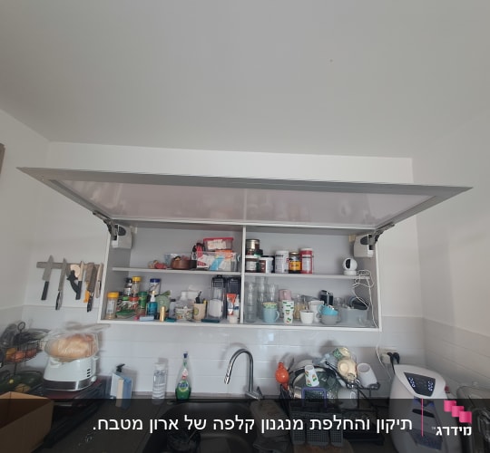 ארון קלפה עליון פתוח במטבח המציג את מנגנוני ההרמה בצדדים